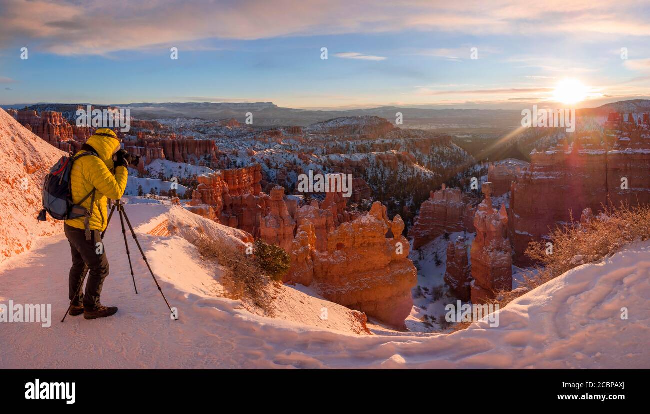 Tourist taking pictures, rock formation Thors Hammer, morning light, sunrise, bizarre snowy rock landscape with hoodoos in winter, Navajo Loop Trail Stock Photo