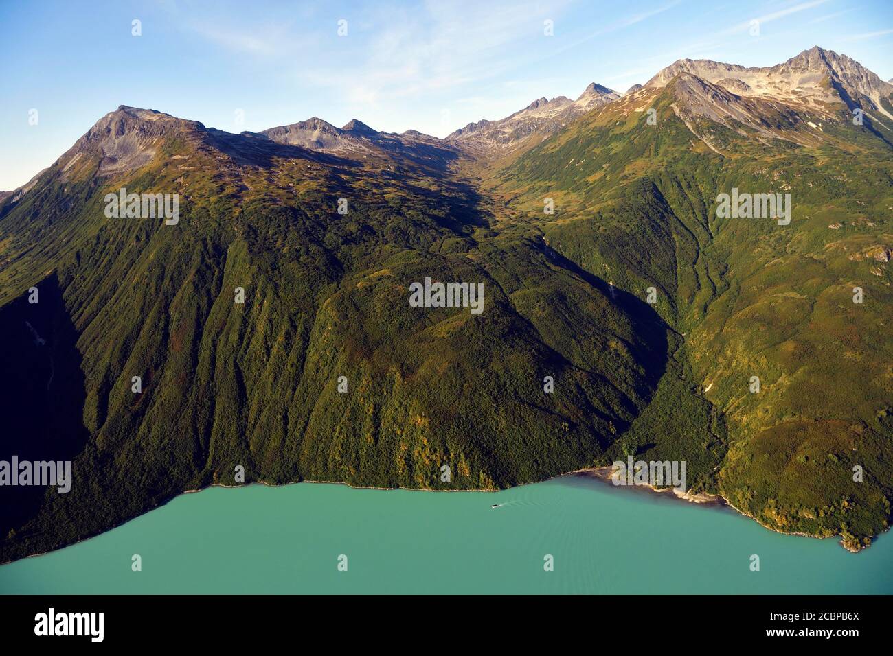 Steep forested mountainsides and an emerald green lake, Lake Clark National Park, Alaska, USA Stock Photo