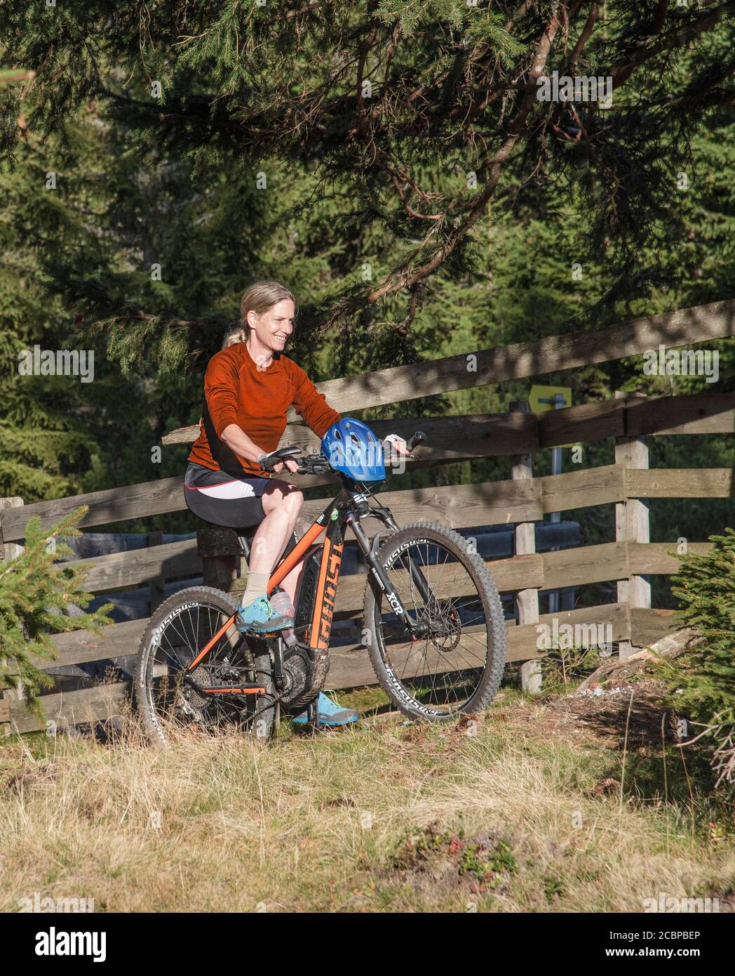 Mountain biker in her late forties on e-MTB rides on forest tracks, Serles, Mieders, Tyrol, Austria Stock Photo