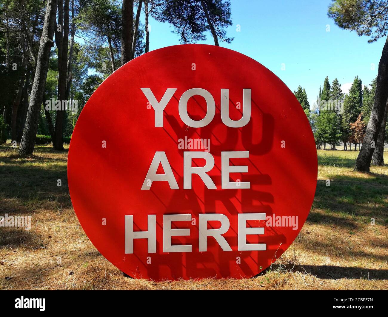 Red circle sign You Are Here  placed on a forested area Stock Photo