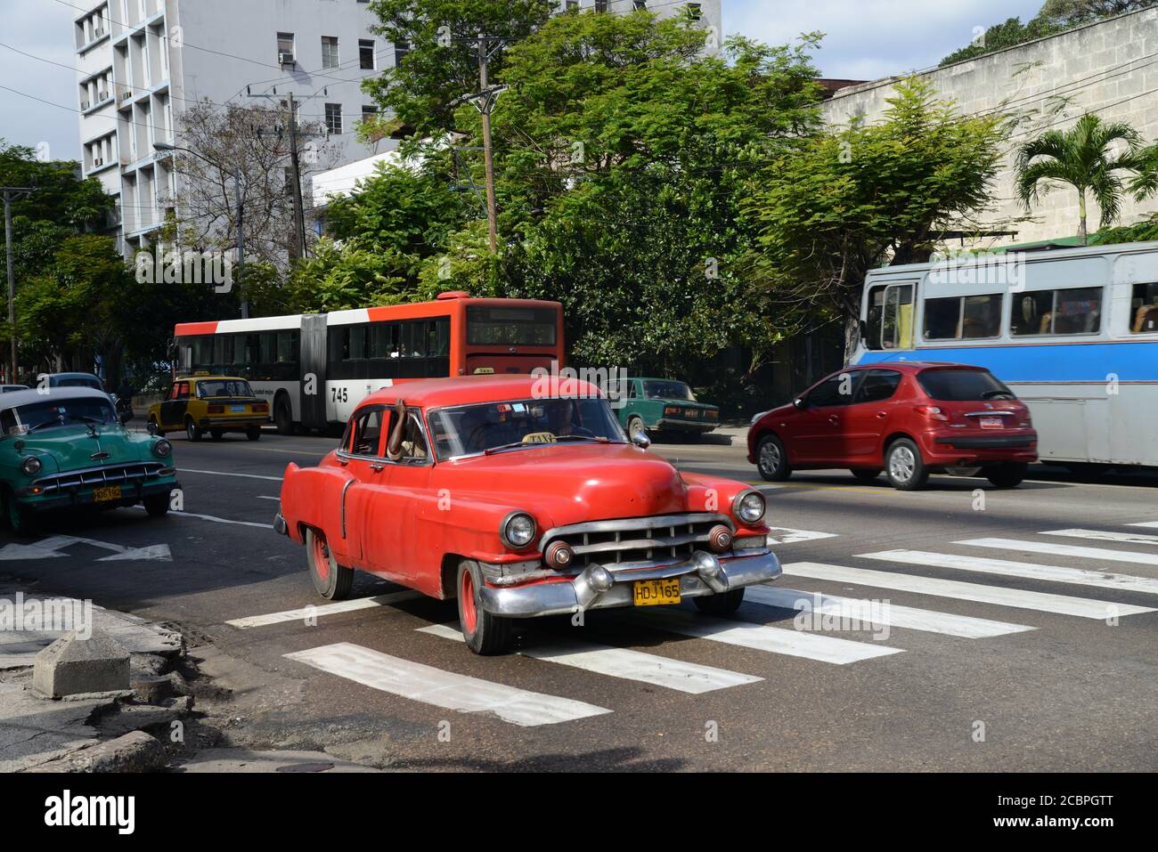 HAVANA, CUBA - Mar 07, 2013: Red American car in Havana dating from 1950s being used as taxi. This is typical of many cars still being driven in Cuba. Stock Photo