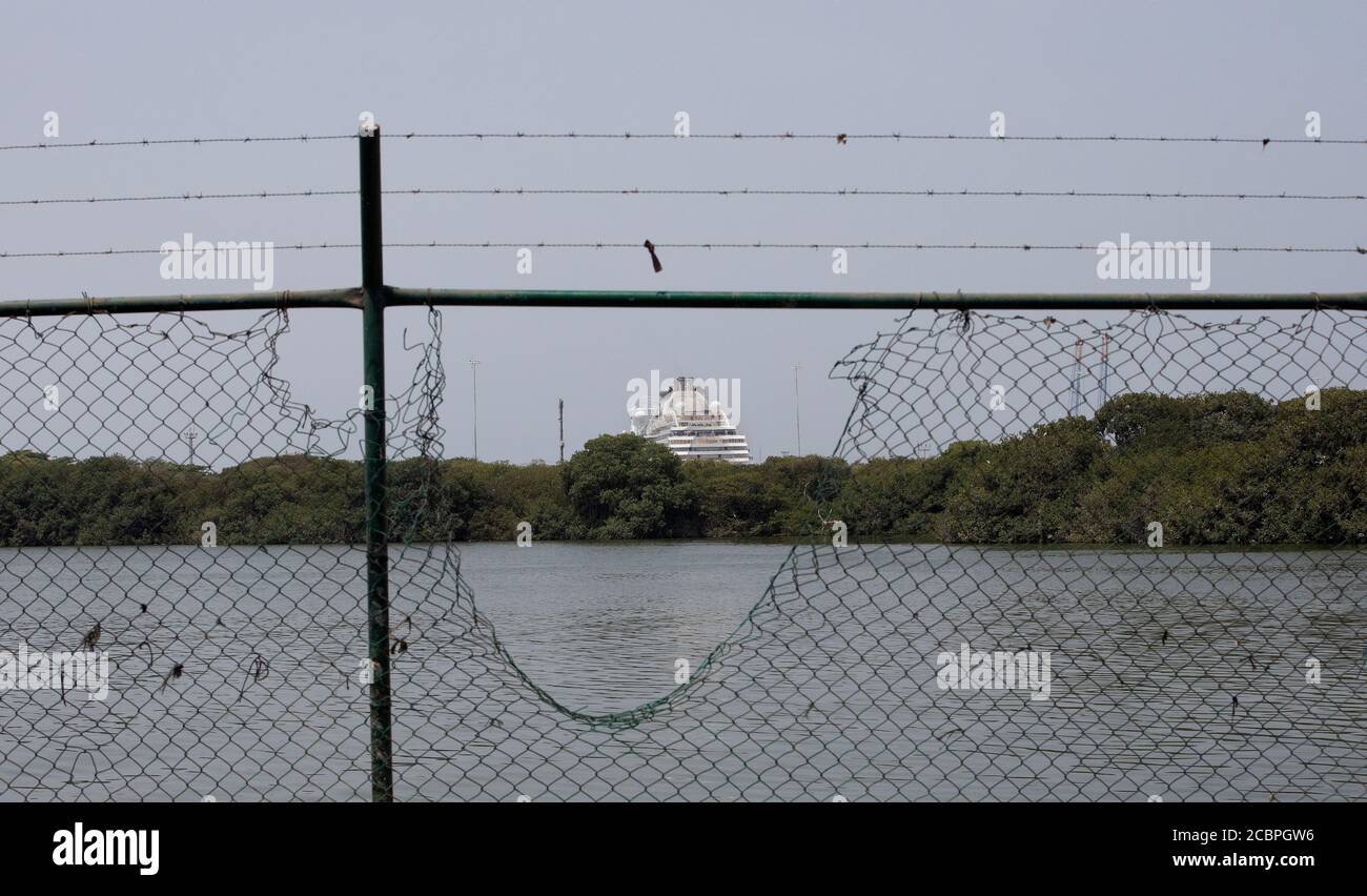 Cartagena Columbia cruise ship through broken fence. 5087. From poor section of the town looking towards the marina and international cruise port. Security fence. Don Despain Rekindle Photo. Stock Photo