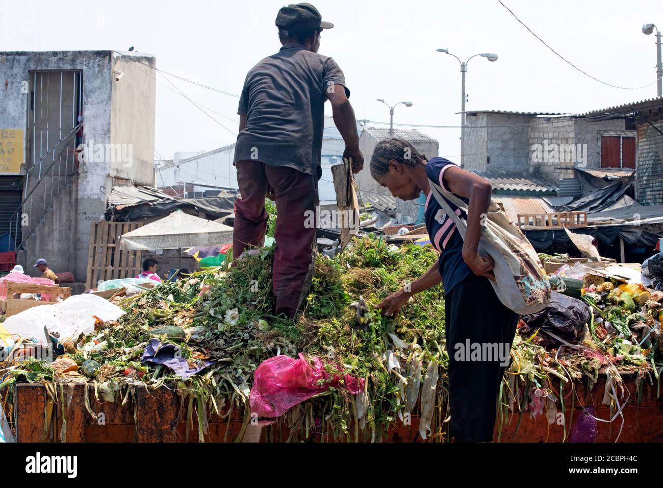 Cartagena Columbia market people scavenge food poor. 5085. Historical poor neighborhood outdoor market. Raw fresh meat beef pork and fish prepared in hot unsanitary conditions. Dirty smelly environmen...