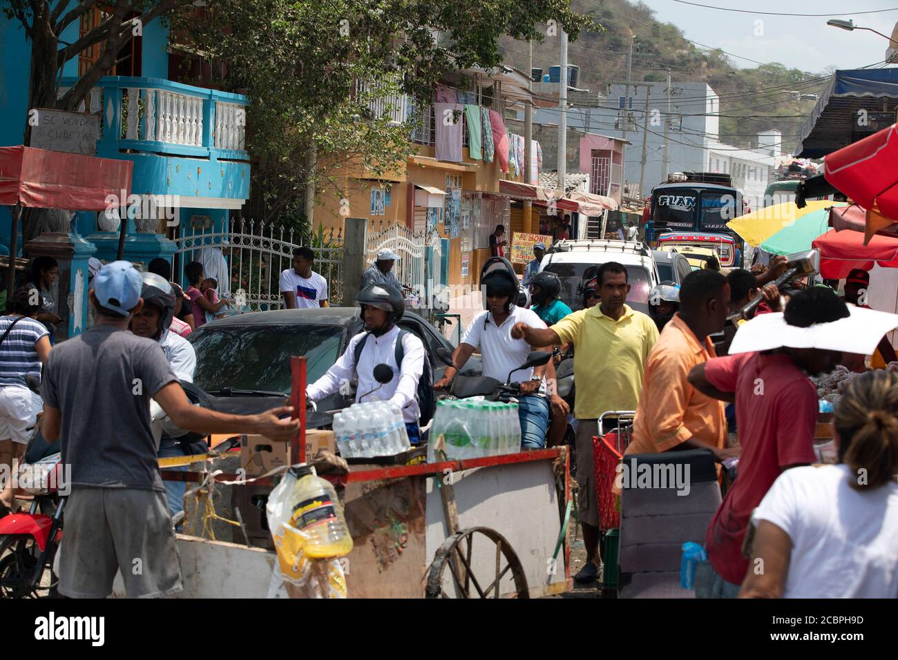 Cartagena Columbia poverty busy street. 5097. Historical poor neighborhood outdoor market. Raw fresh meat, beef, pork and fish prepared in hot unsanitary conditions. Dirty, smelly environment with rotten food. Local restaurants and shopping. Stock Photo