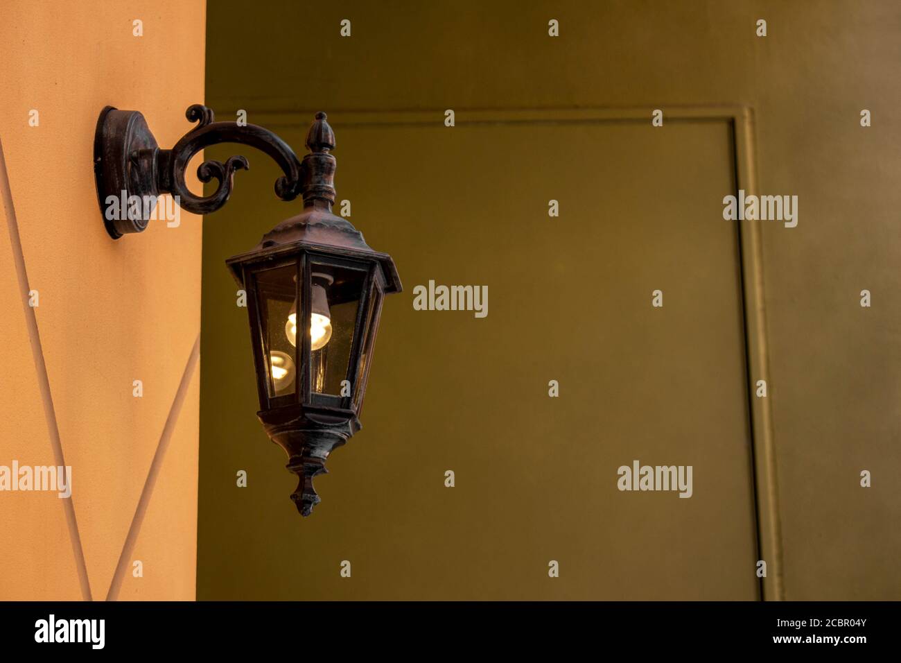 Antique style outdoor light on the exterior wall in Southern European colors Stock Photo