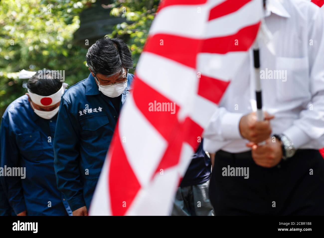 Tokyo, Japan. 15th Aug, 2020. Japanese nationalists offer a silent tribute to the war dead during the 75th anniversary of Japan's surrender in World War II at Yasukuni Shrine. This year, the temple has set signboards promoting the social distancing to prevent the spreading of the new coronavirus (COVID-19) disease at the Yasukuni Shrine. Credit: Rodrigo Reyes Marin/ZUMA Wire/Alamy Live News Stock Photo