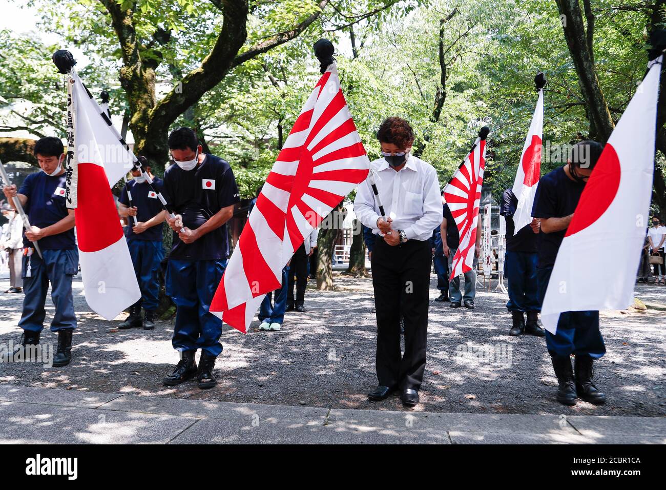 Tokyo, Japan. 15th Aug, 2020. Japanese nationalists offer a silent tribute to the war dead during the 75th anniversary of Japan's surrender in World War II at Yasukuni Shrine. This year, the temple has set signboards promoting the social distancing to prevent the spreading of the new coronavirus (COVID-19) disease at the Yasukuni Shrine. Credit: Rodrigo Reyes Marin/ZUMA Wire/Alamy Live News Stock Photo