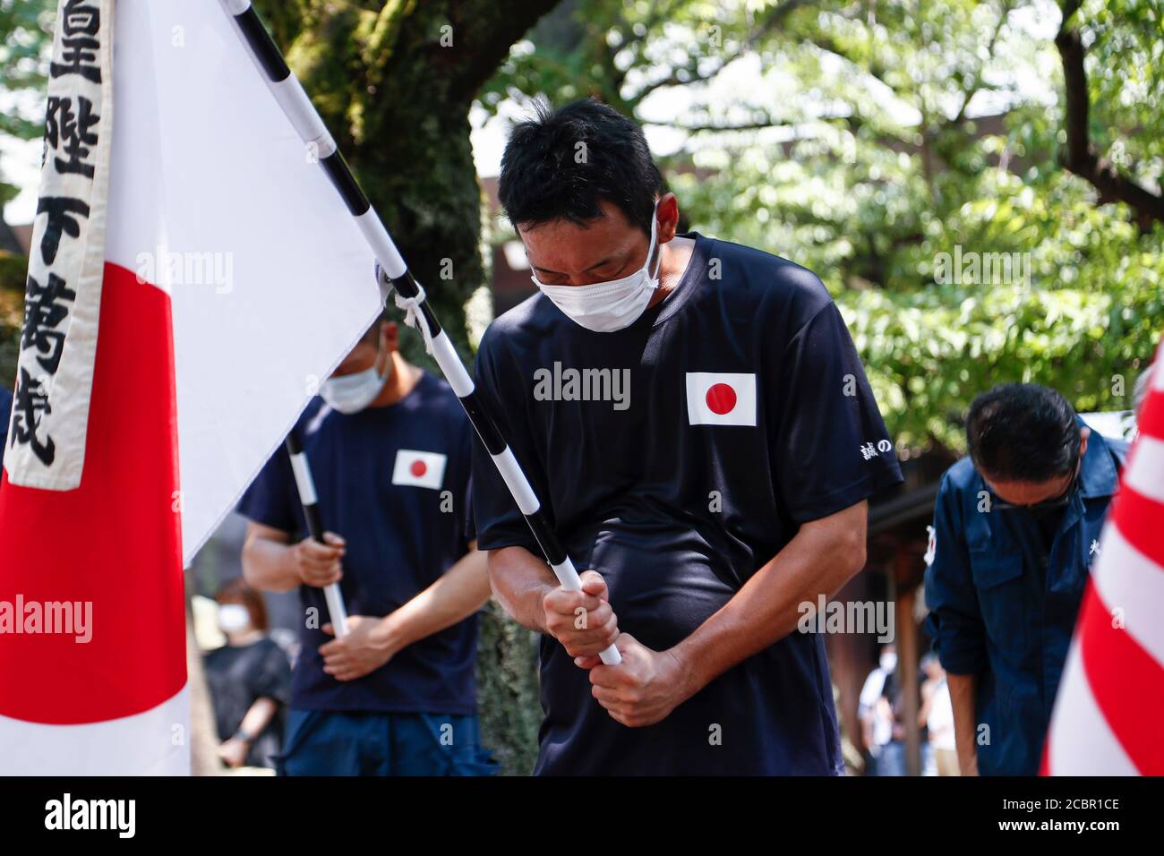Tokyo, Japan. 15th Aug, 2020. Japanese nationalists offer a silent tribute to the war dead during the 75th anniversary of Japan's surrender in World War II at Yasukuni Shrine. This year, the temple has set signboards promoting the social distancing to prevent the spreading of the new coronavirus (COVID-19) disease at the Yasukuni Shrine. Credit: Rodrigo Reyes Marin/ZUMA Wire/Alamy Live News Stock Photo