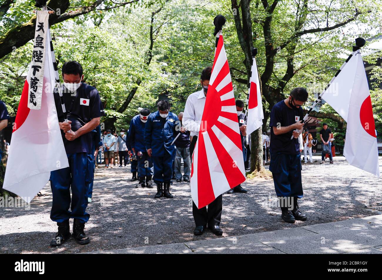 Tokyo, Japan. 15th Aug, 2020. Japanese nationalists offer a silent tribute to the war dead during the 75th anniversary of Japan's surrender in World War II at Yasukuni Shrine. This year, the temple has set signboards promoting the social distancing to prevent the spreading of the new coronavirus (COVID-19) disease at the Yasukuni Shrine. Credit: Rodrigo Reyes Marin/ZUMA Wire/Alamy Live News Stock Photo