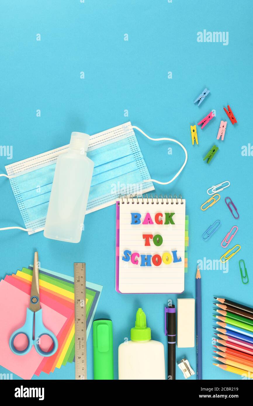Flat lay shot of school items on a blue surface. Back to school after the pandemic Stock Photo