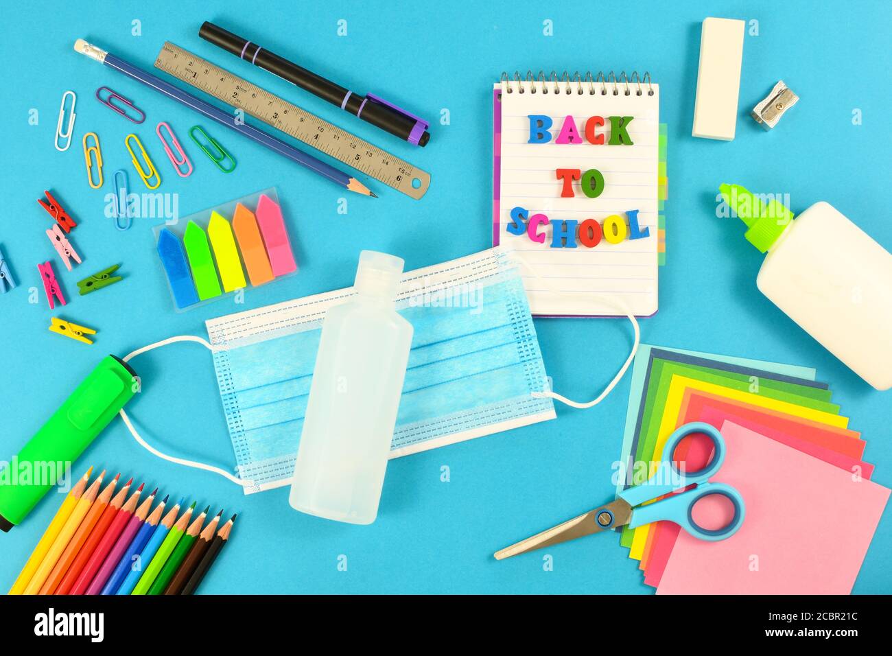 Flat lay shot of school items on a blue surface. Back to school after the pandemic Stock Photo