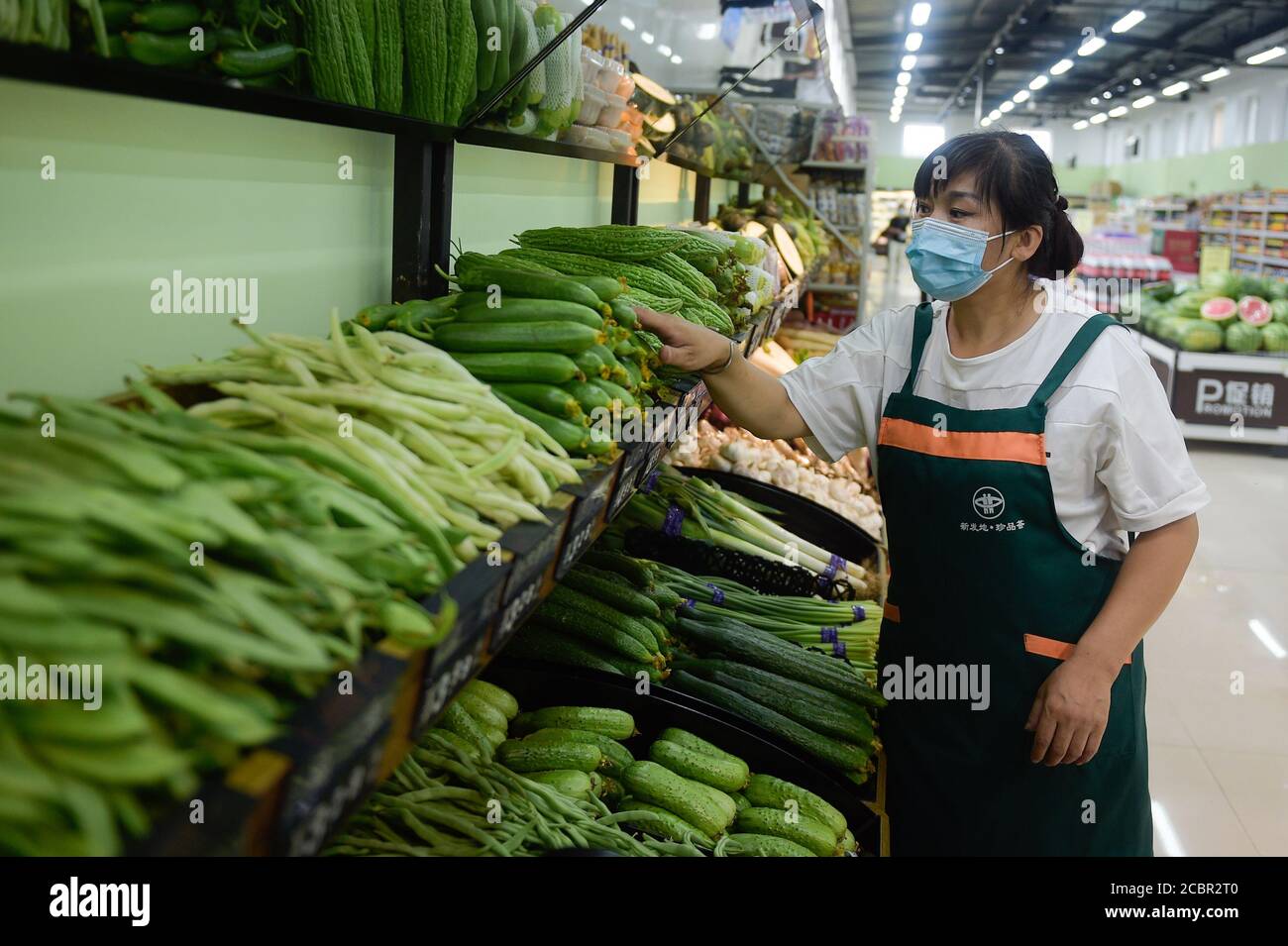 200815) -- BEIJING, Aug. 15, 2020 (Xinhua) -- A staff member puts  vegetables in order at a retail grocery store which has been set up  recently next to the Xinfadi wholesale market