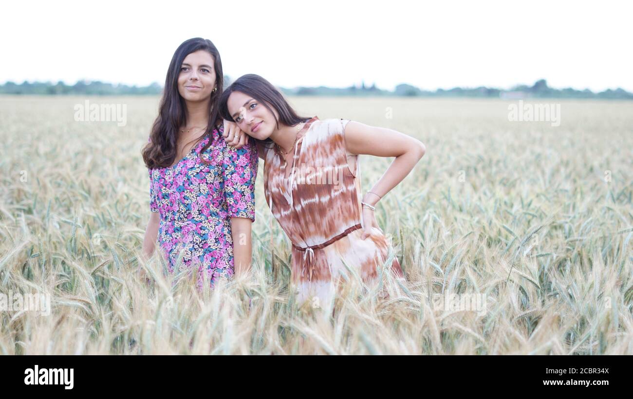 Closeup shot of pretty young brunettes posing in the field - friendship concept Stock Photo