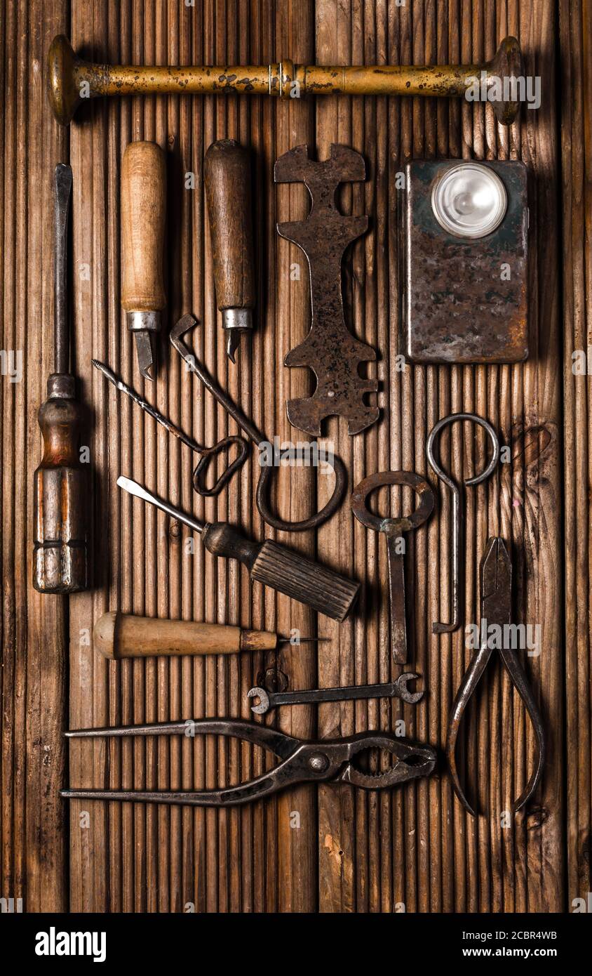 Collection of rusty tools and keys in vintage style on wooden background Stock Photo