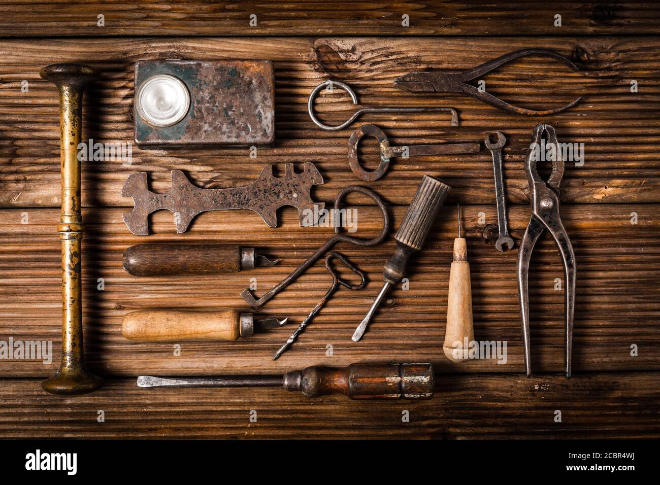 Collection of rusty tools and keys in vintage style on wooden background Stock Photo