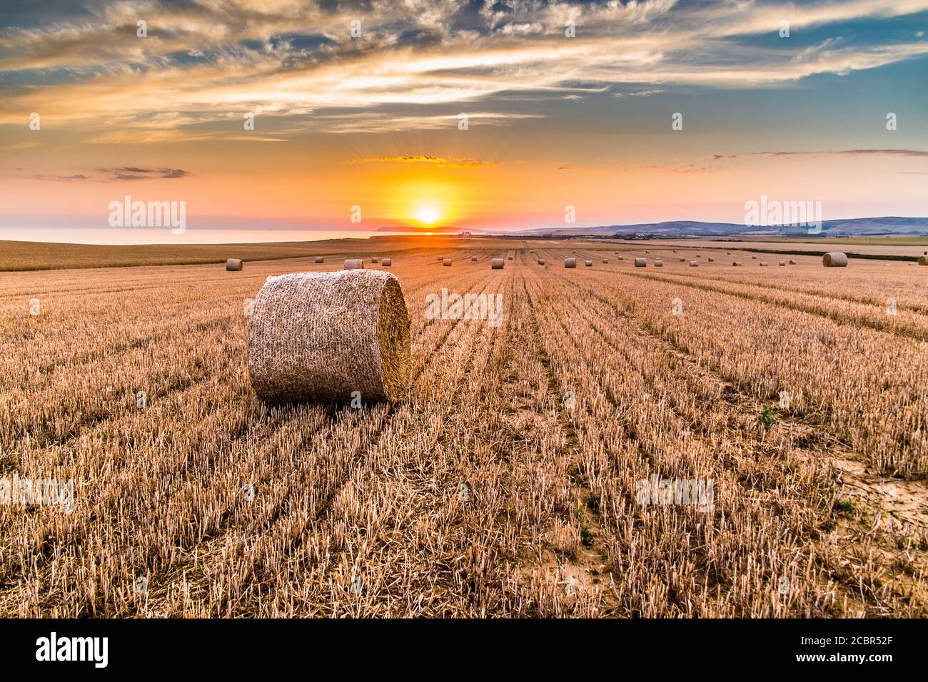 West Wight sunset in field of round bales Stock Photo