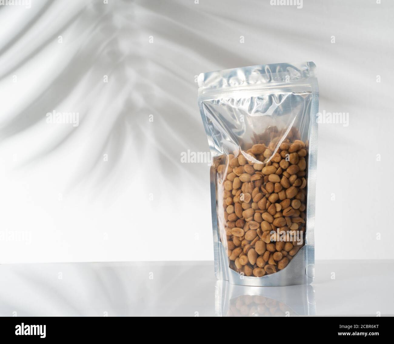 blank standing pouch mockup with nuts on transparent window Stock Photo