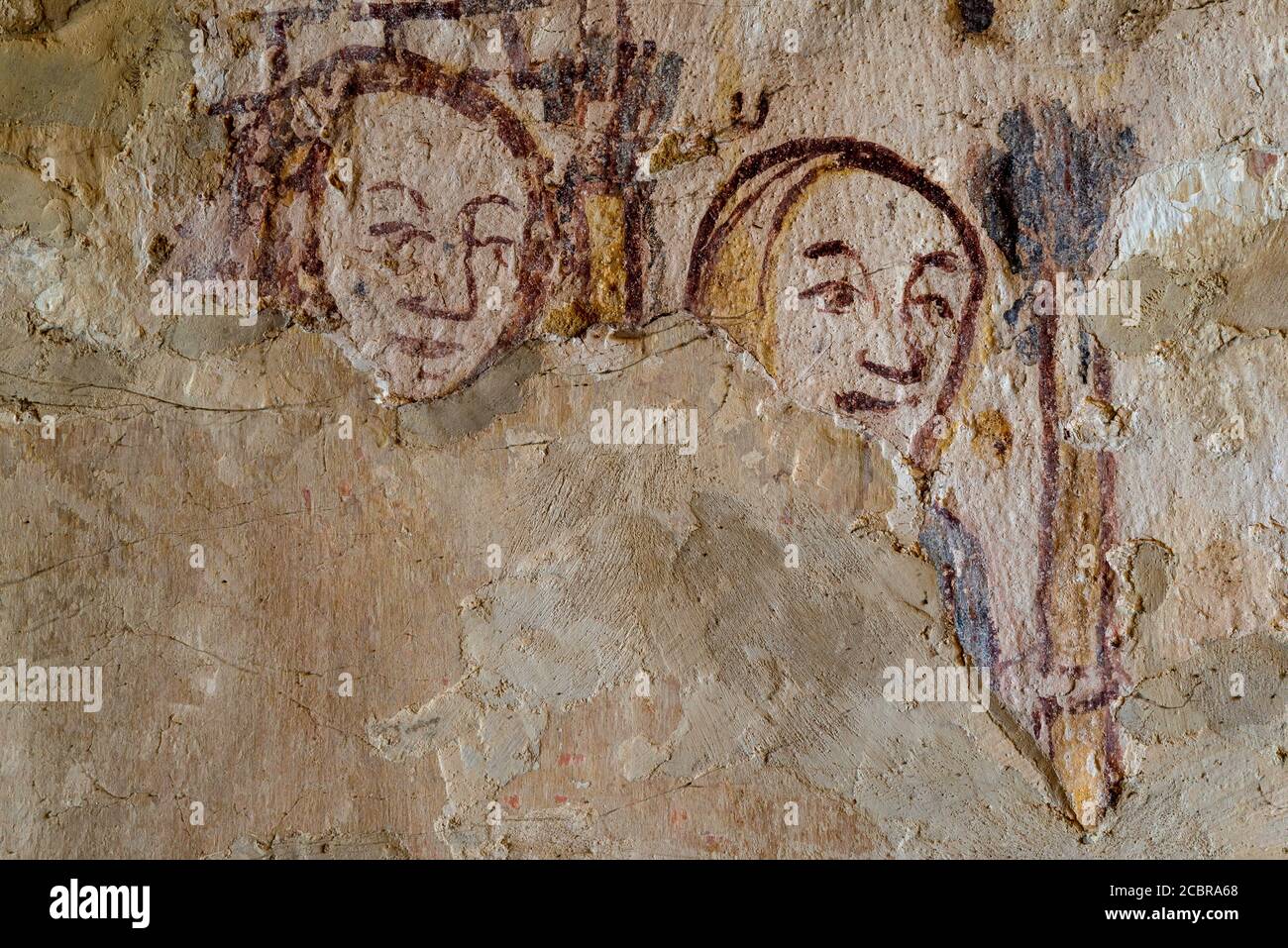 Two faces from the 1200s or 1300s.  Medieval wall painting in Parish Church of St Mary in the Cotswolds, at Ampney St. Mary, Gloucestershire, England. Stock Photo
