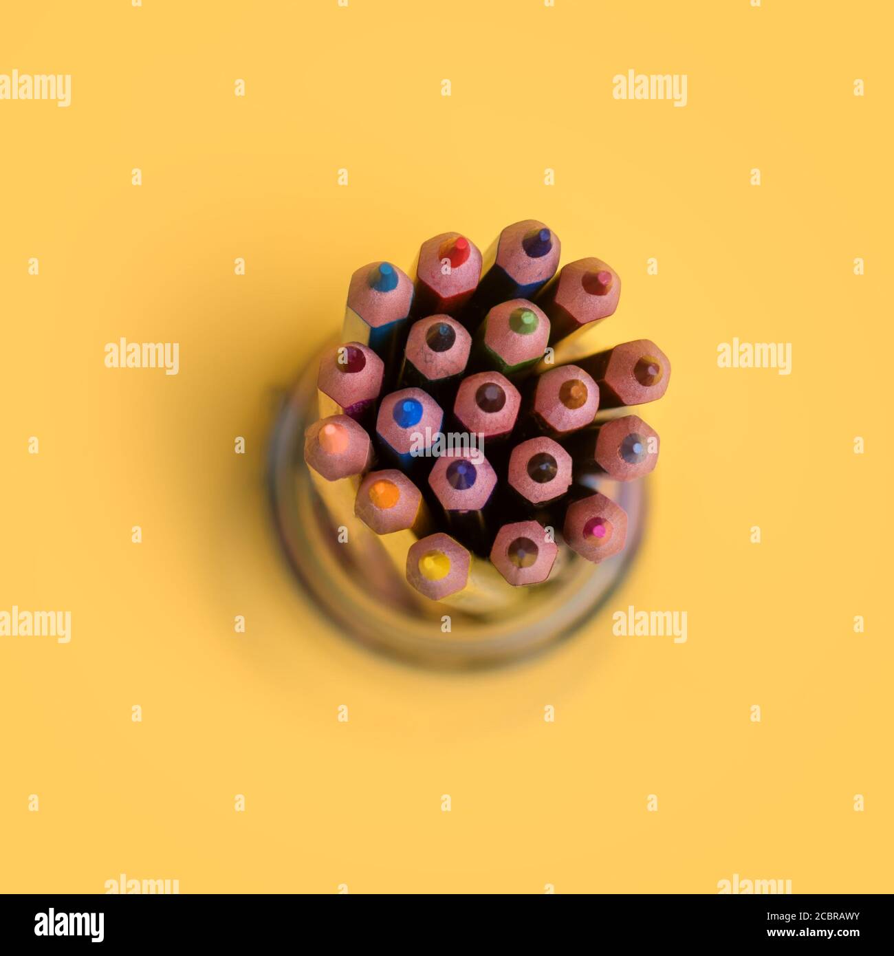 Сolored pencils in a jar on a yellow background Stock Photo