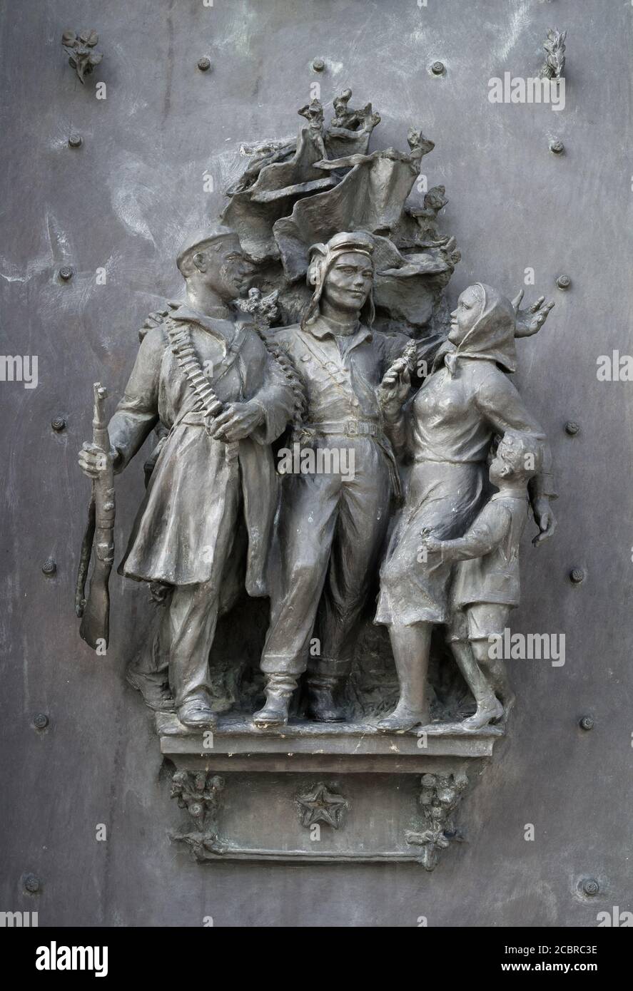 Soldiers as liberators and civilian family are celebrating liberation and victory in war and warfare. Statue made in style of socialist realism. Stock Photo