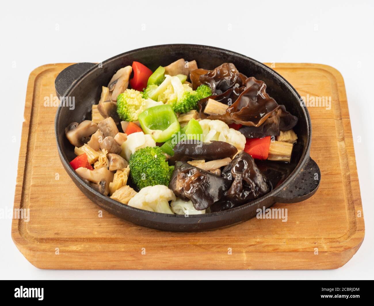 Vegetables on a hot frying pan (Peppers, black mushrooms, Chinese asparagus, broccoli, cauliflower, mushrooms, spices, onion oil, sesame oil) Stock Photo
