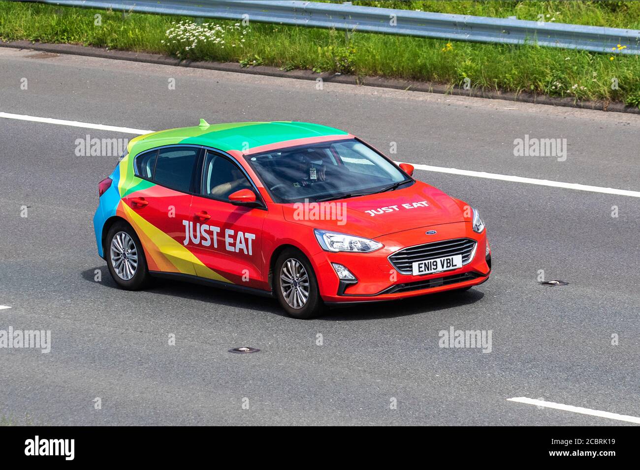 Just Eat takeaway online foods delivery 2019 Ford Focus Titanium TDCI ; Vehicular traffic moving vehicles, commercial vans, food courier on the Just Eat network, takeaway business vehicle, cars driving vehicle on UK roads, motors, motoring on the M6 motorway highway network. Stock Photo