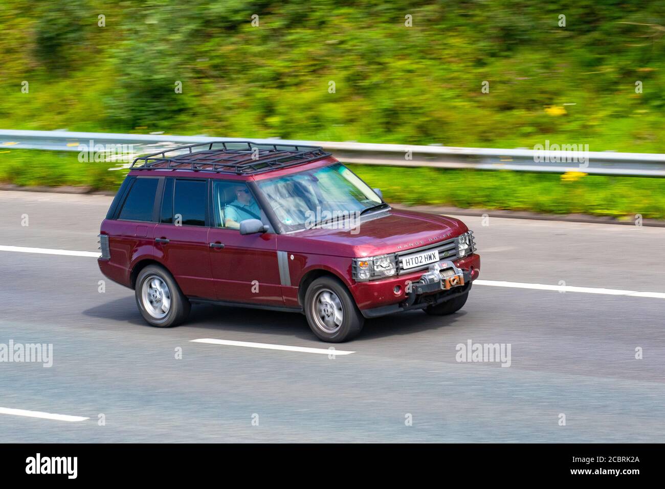 2002 red Land Rover Range Rover HSE V8 Auto; Vehicular traffic moving vehicles, cars driving vehicle on UK roads, motors, motoring on the M6 motorway highway network. Stock Photo