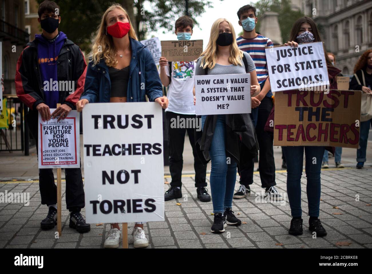 Students wearing face masks take part in a protest in Westminster in London over the government's handling of A-level results, university provision and bleak employment prospects. Stock Photo