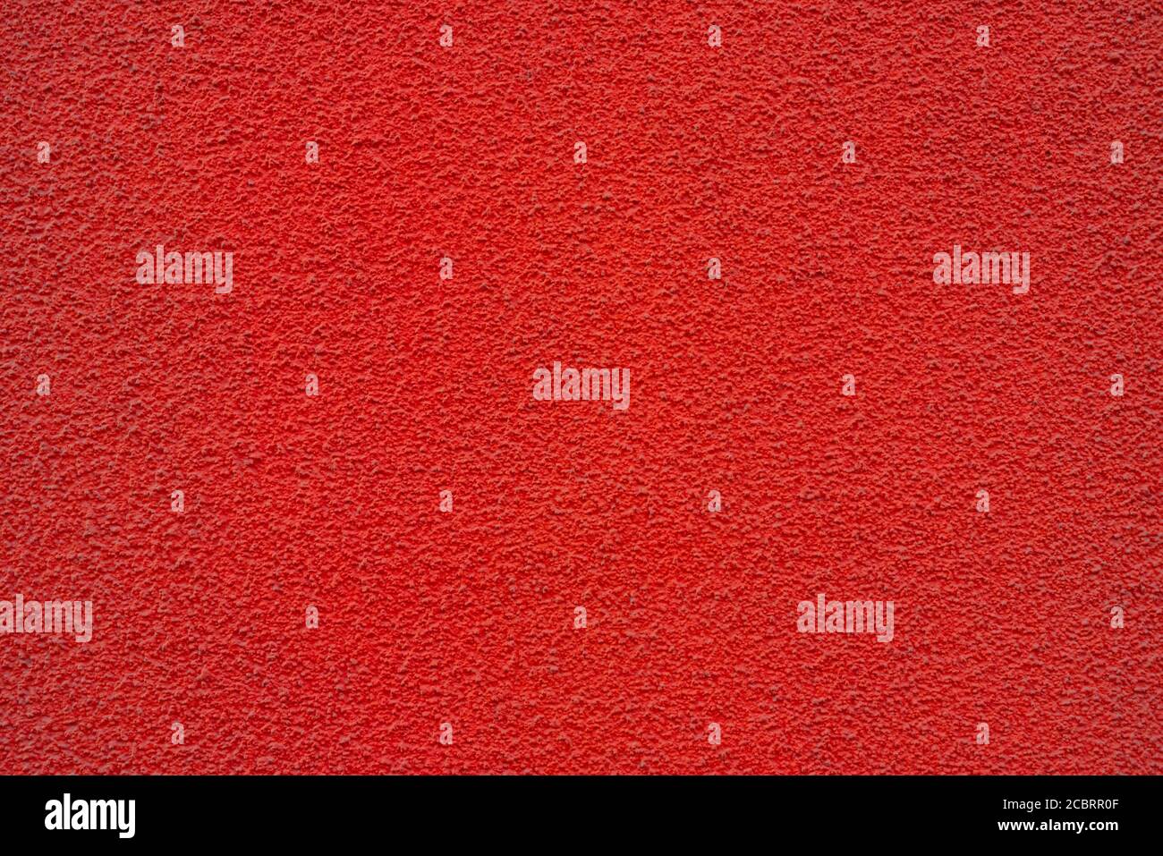 Red wall of the building. Rough plaster surface. Abstract background ...