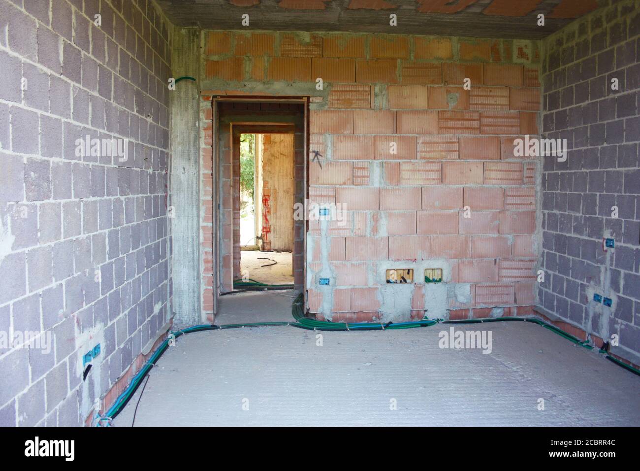 room under construction with concrete and brick in a building structure