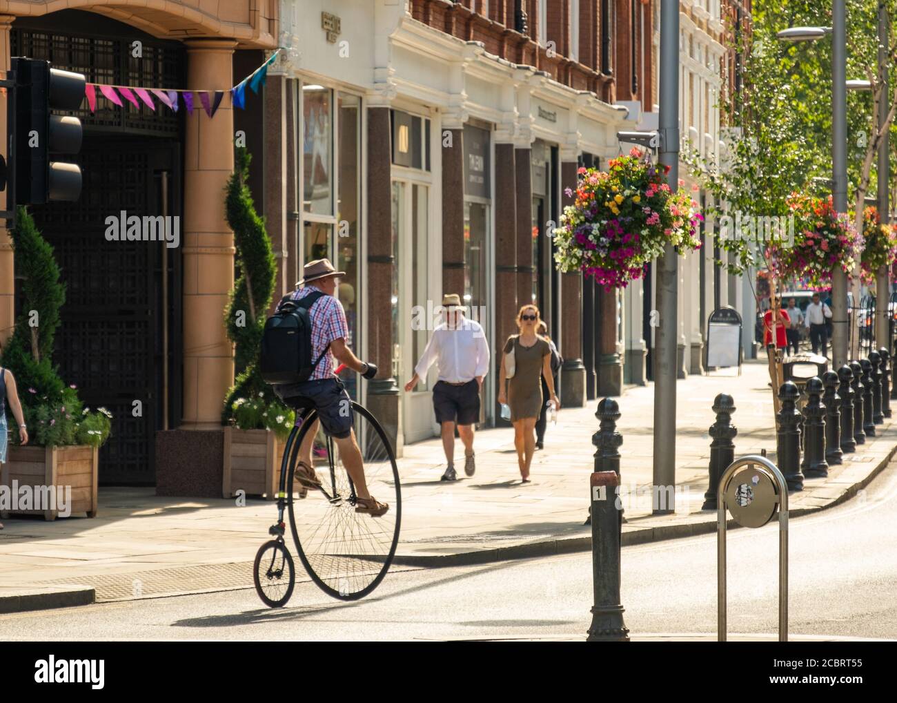 London- August, 2020: A man on a penny farthing bike on the Kings Road, Chelsea Stock Photo