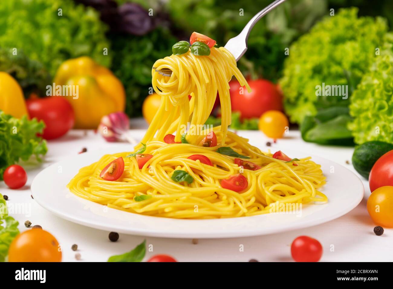 Plate of italian pasta, spaghetti on fork with tomatoes and basil Stock Photo