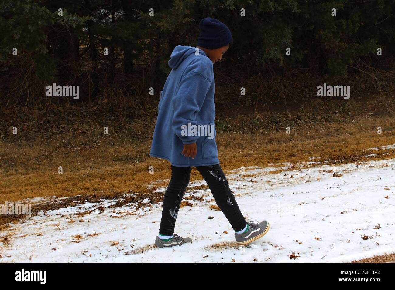 Boy in Beanie (African American, Black) Walking in the Snow Middle of Winter in the Midwest United States Stock Photo
