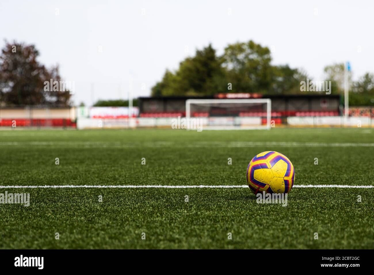 Football on empty 3G football pitch with goal in the background. Ground is Bedfont Sports Ground, London. Stock Photo
