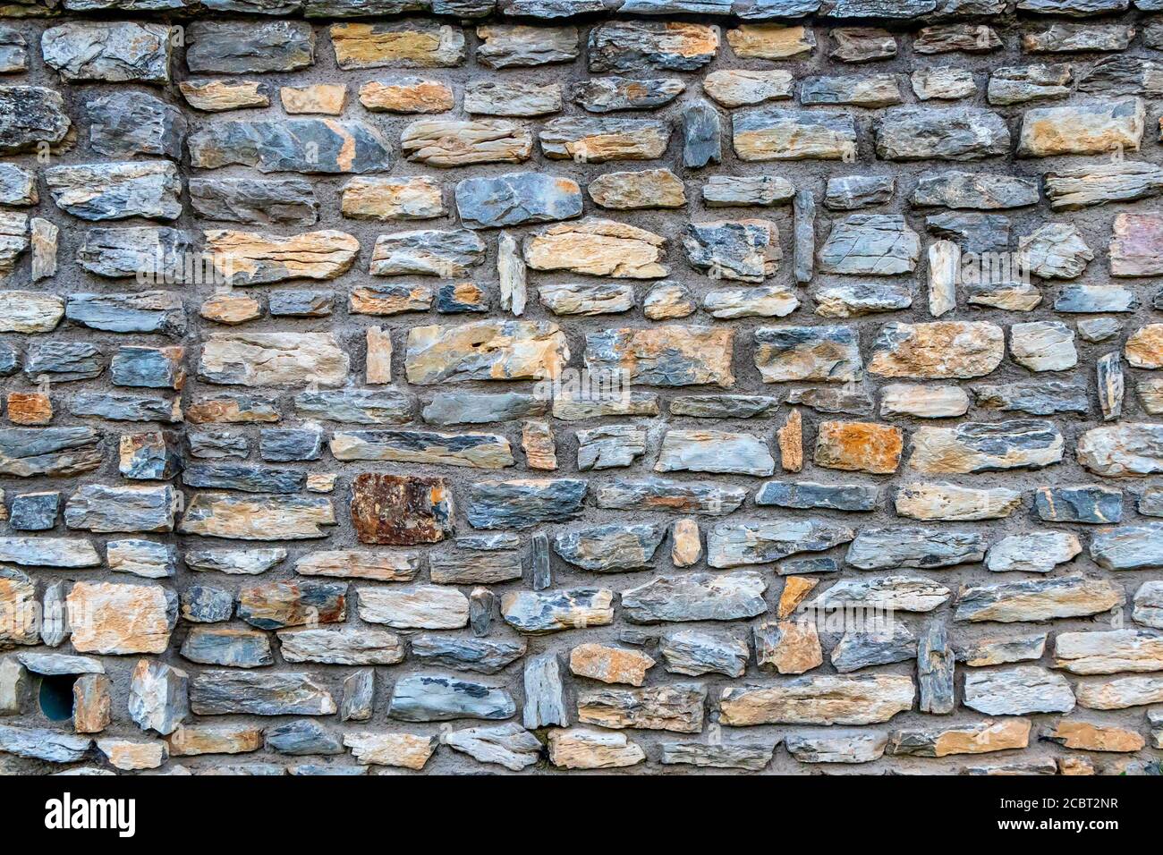 Flat picture of a stone wall made of natural rocks Stock Photo