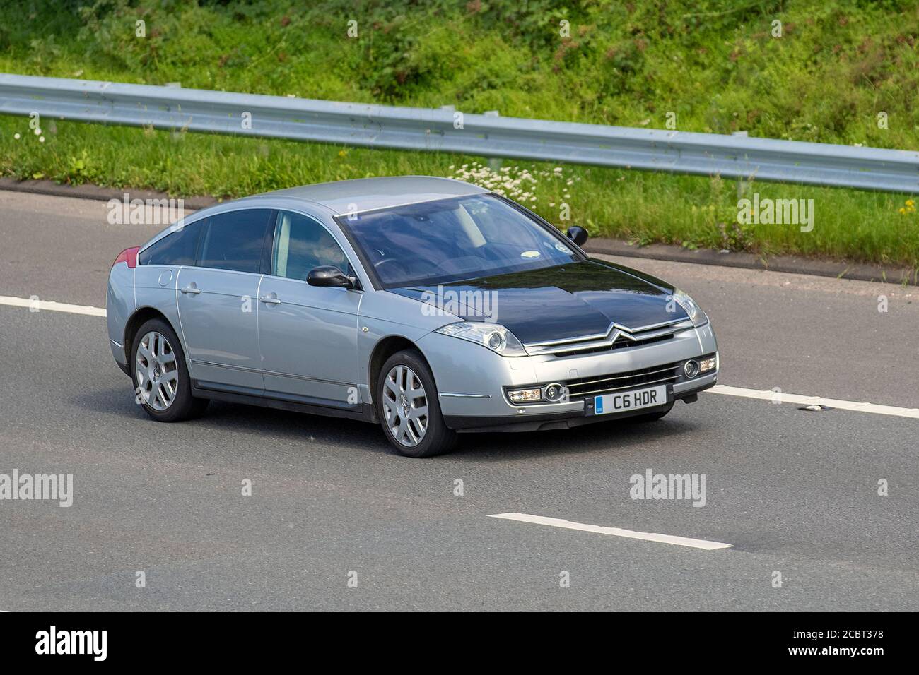 2006 silver black French Citroën C6 Exclusive 4dr Auto; Vehicular traffic moving vehicles, cars driving vehicle on UK roads, french motors, motoring on the M6 motorway highway network. Stock Photo