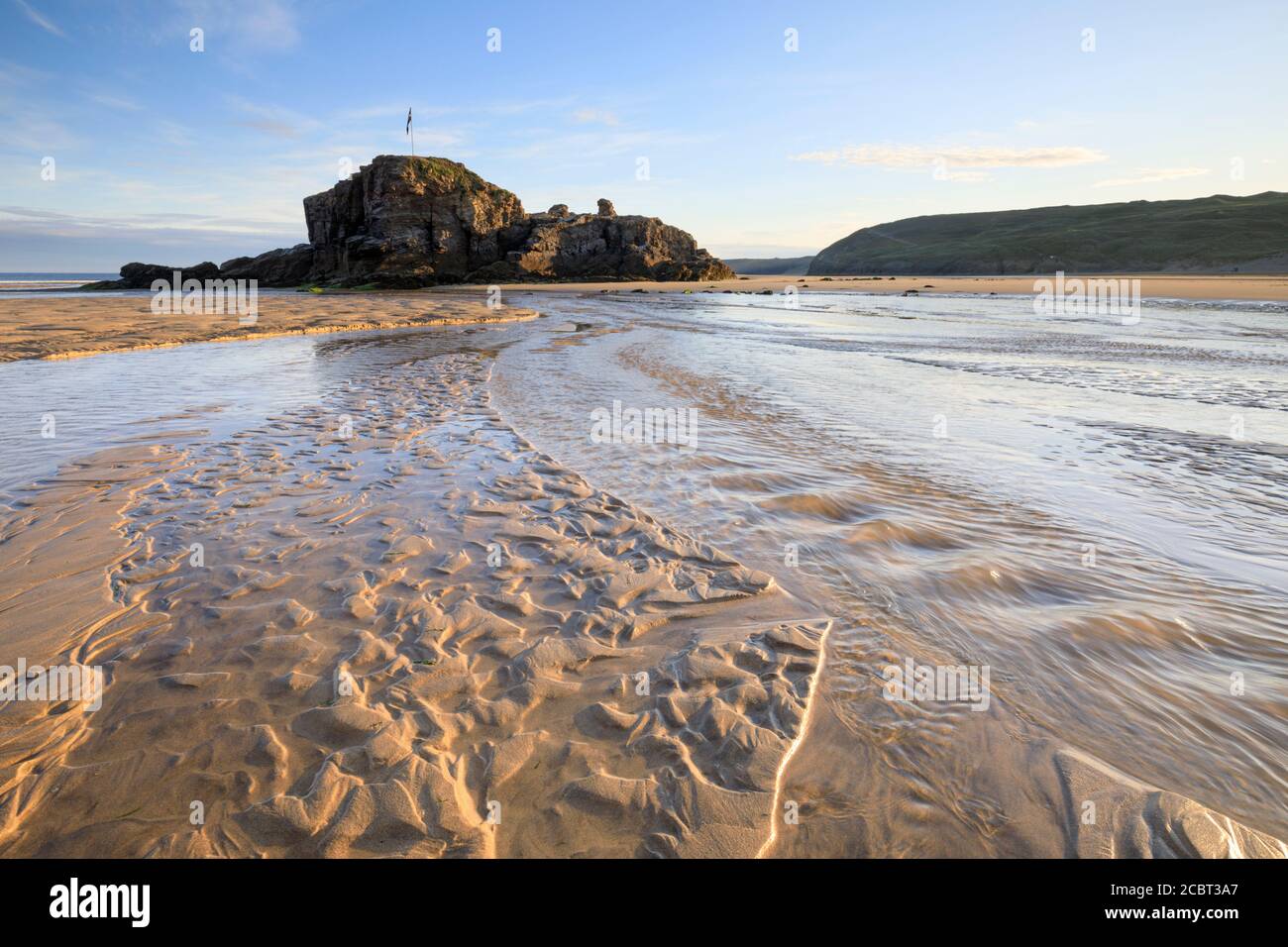 Chapel Rock on Perranporth Beach in Cornwall captured on a morning in mid-July with sand patterns as foreground interest. Stock Photo