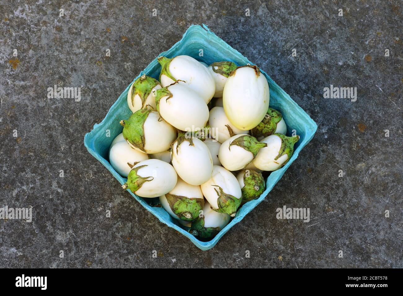 Container of white baby eggplants Stock Photo
