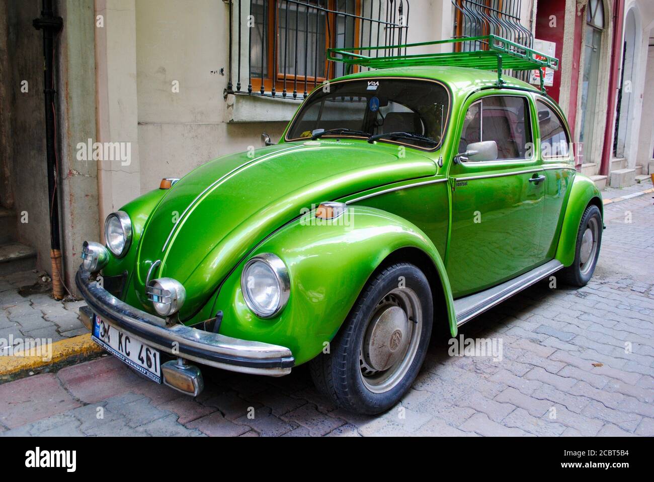 A green shining classic Volkswagen Beetle car parked on an an old street in Istanbul.  Stock Photo