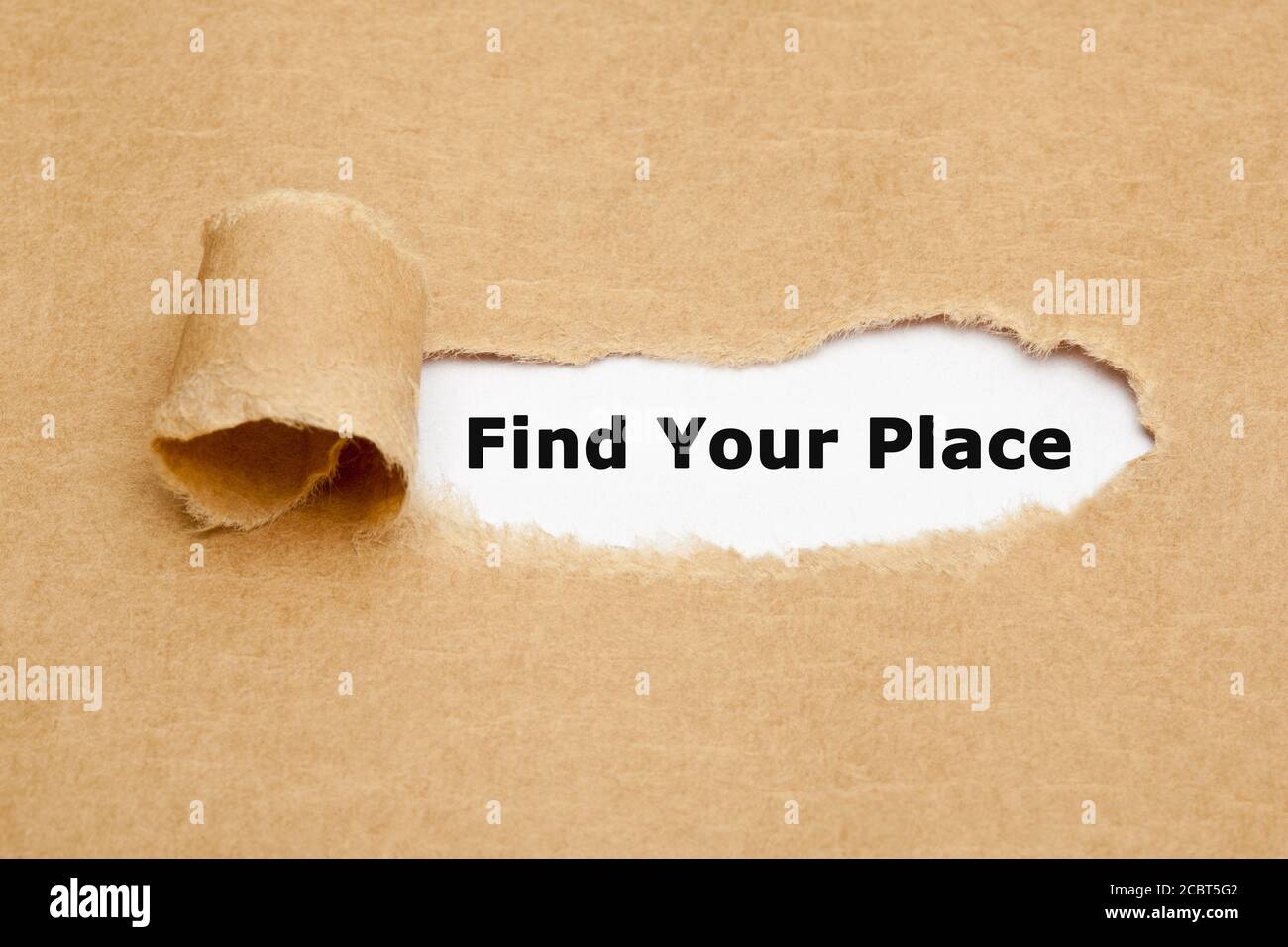 Concept with printed text Find Your Place appearing behind ripped brown paper. Stock Photo