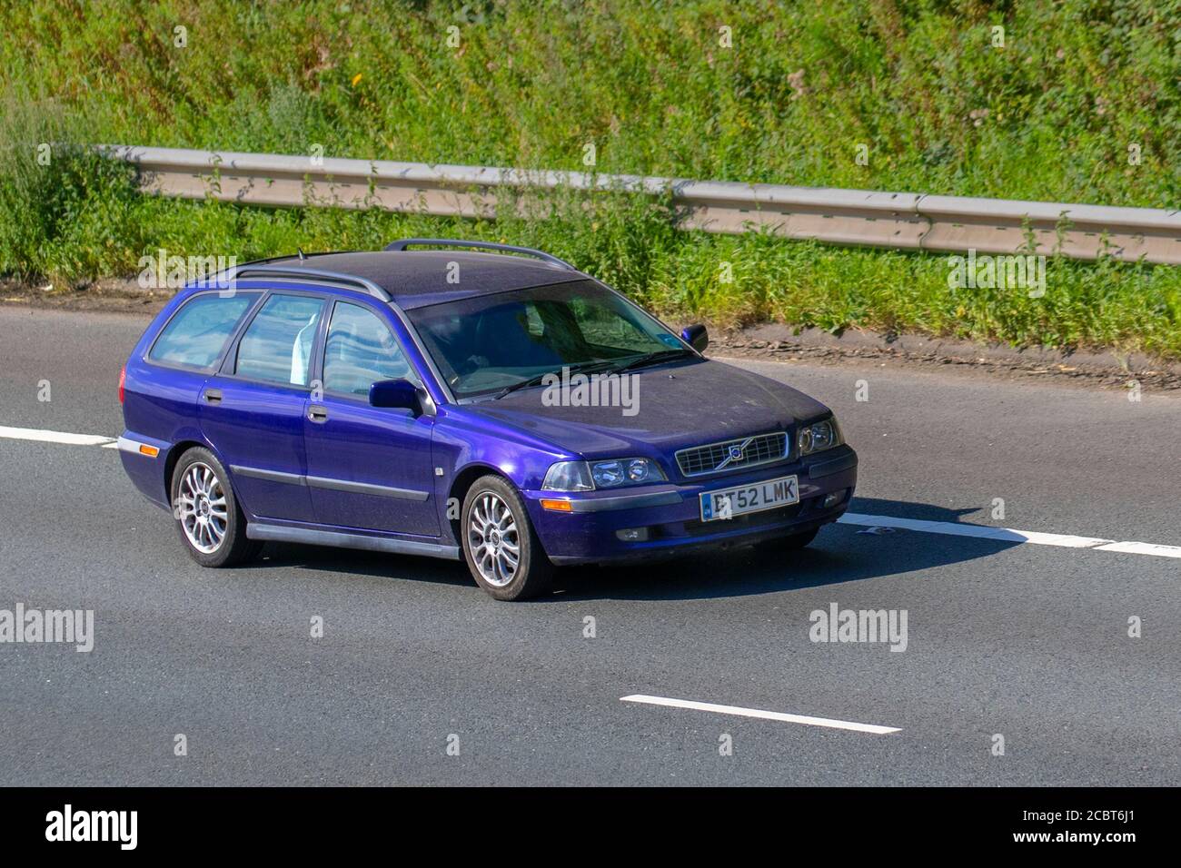 2002 blue Volvo V40 Sport estate; Vehicular traffic moving vehicles, cars driving vehicle on UK roads, motors, motoring on the M6 motorway highway network. Stock Photo