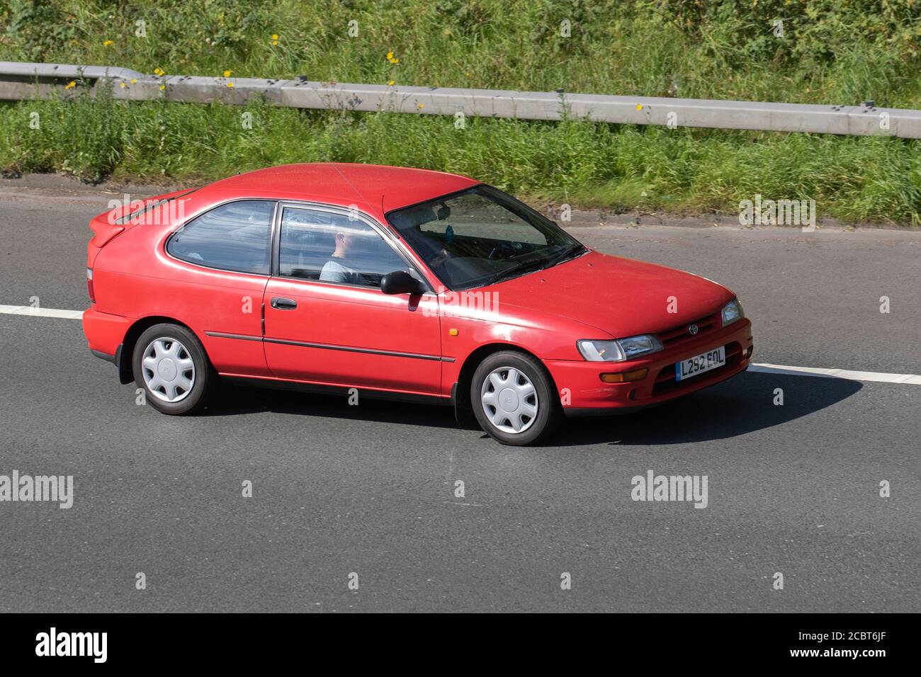 1994 90s nineties red Toyota Corolla GLI; Vehicular traffic moving vehicles, cars driving vehicle on UK roads, motors, motoring on the M6 motorway highway network. Stock Photo