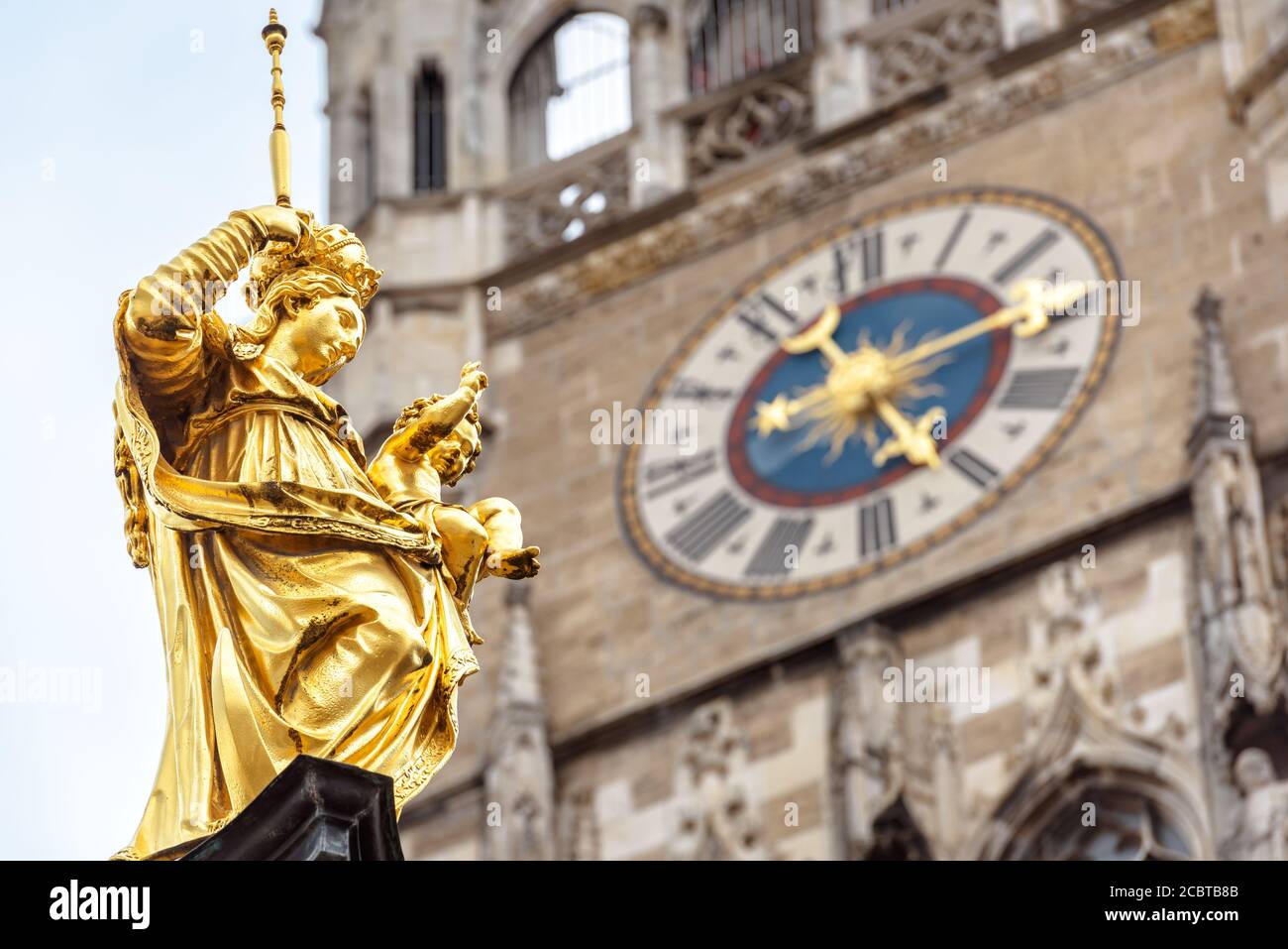 Virgin Mary statue closeup in Marienplatz square, Munich, Germany. This place is a top landmark of Munich. Golden sculpture atop Mariensaule column on Stock Photo