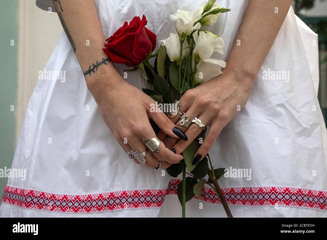 Moscow, Russia. 15th of August, 2020 Women hold flowers as people, some of them ethnic Belarusians, gather for a rally against the results of the Belarusian presidential election in front of Belarusian Embassy in Moscow, Russia. About 400 people, mostly women, line up with flowers along Maroseyka street near Belarusian Embassy in solidarity with protesters injured in the latest rallies in Belarus Stock Photo