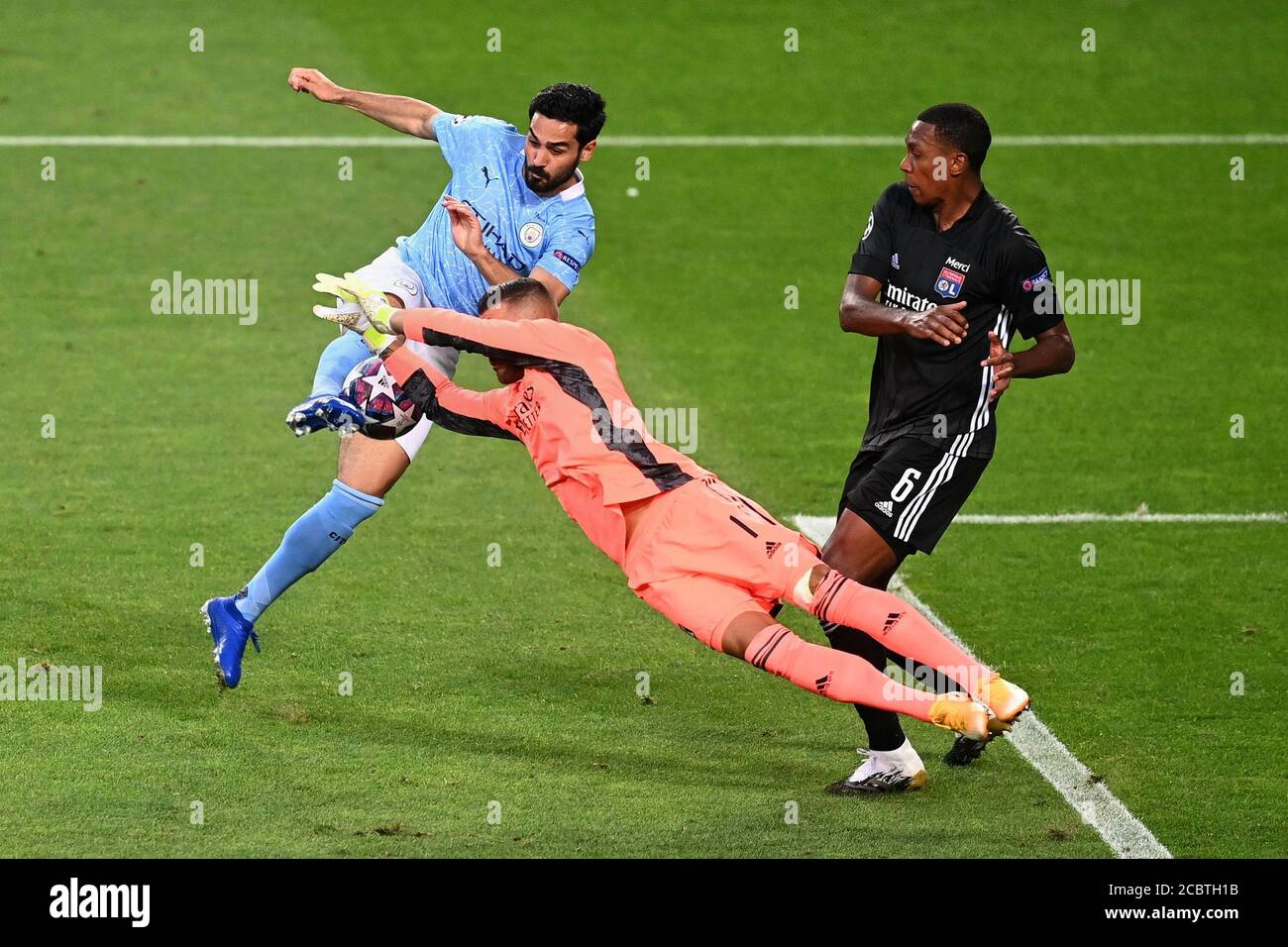 Lisbon, Portugal. 15th Aug, 2020. Anthony Lopes (C) of Olympique Lyon saves from Ilkay Gundogan (L) of Manchester City during the UEFA Champions League Quarter Final match between Manchester City and Olympique Lyon in Lisbon, Portugal, Aug. 15, 2020. Credit: Michael Regan/UEFA/Handout via Xinhua/Alamy Live News Stock Photo
