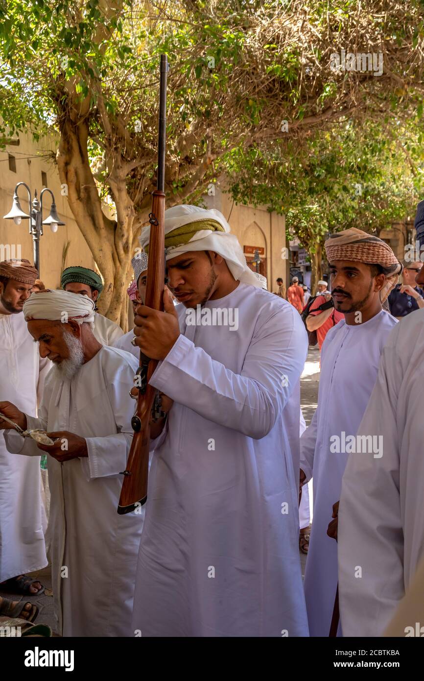 Oman man checking a rifle at the street market Stock Photo