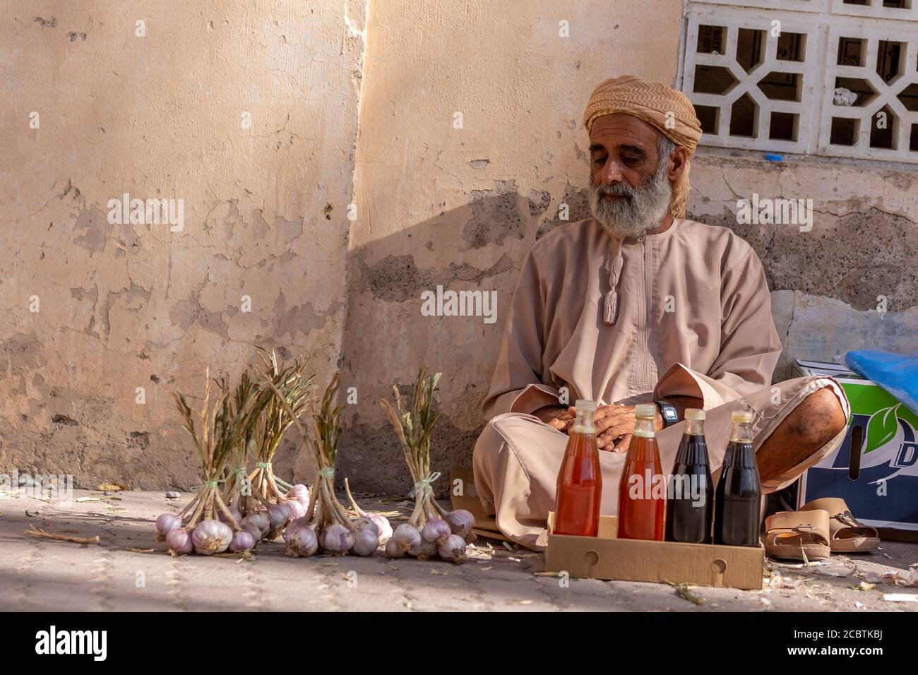 An Omani man selling Honey and garlic at Nizwa souq Stock Photo