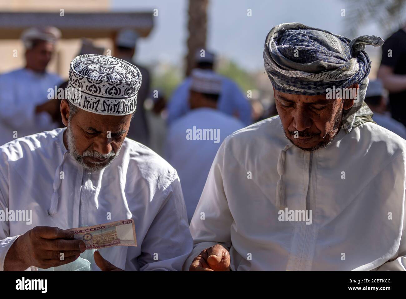 Omani men exchange money Stock Photo