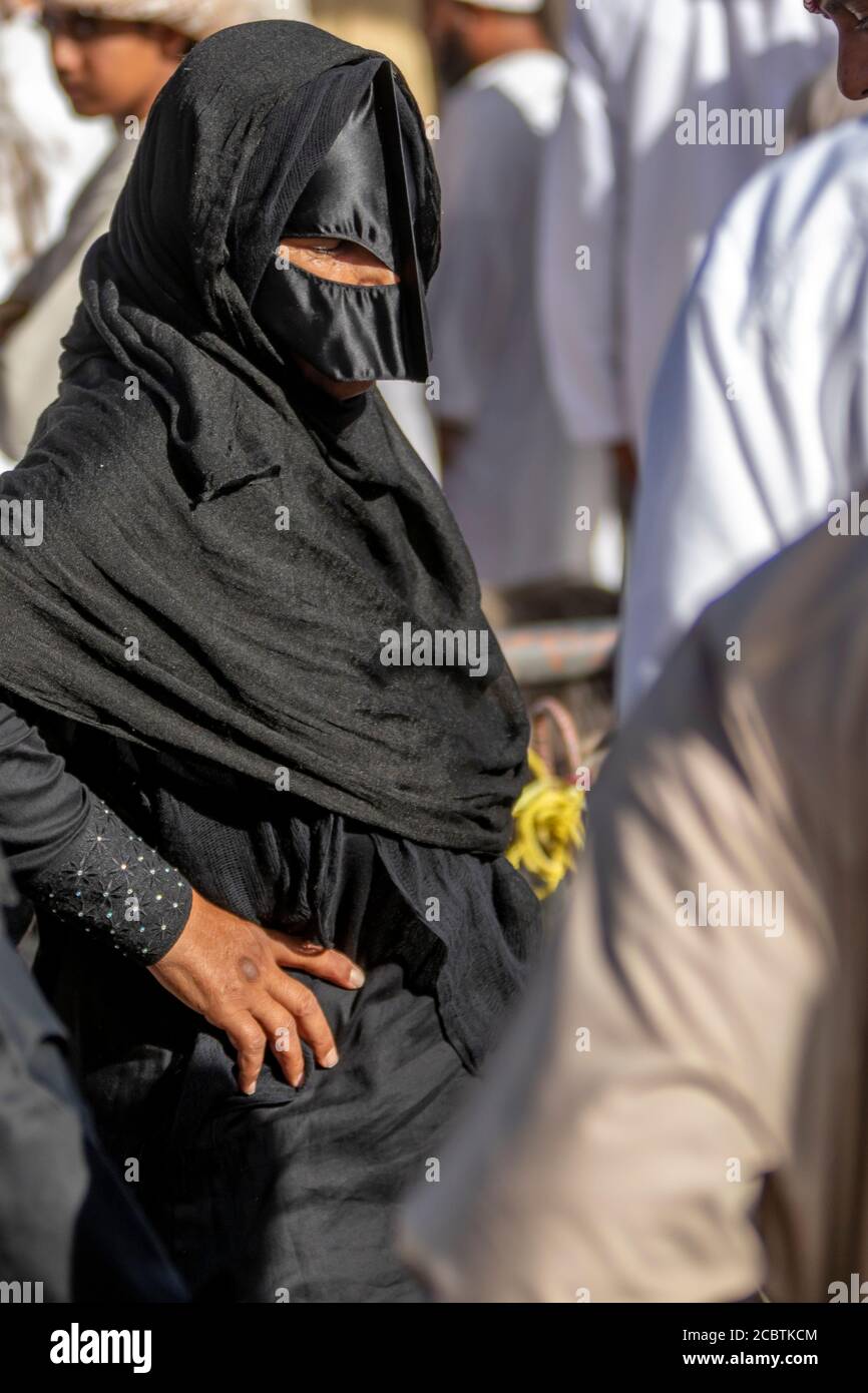 Omani lady wearing abaya selling goat at the Nizwa fort Stock Photo