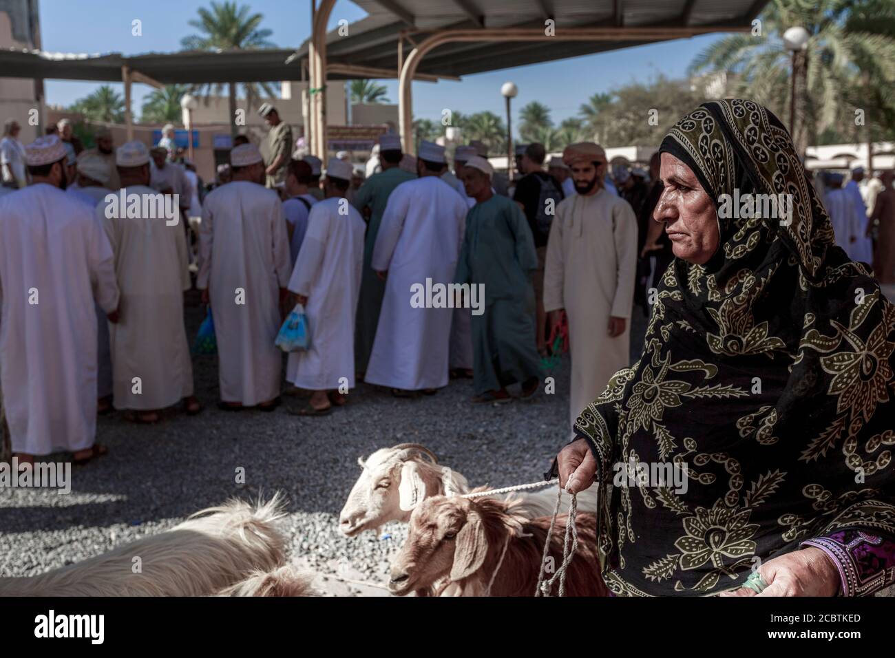 Omani lady wearing abaya selling goat at the Nizwa fort Stock Photo